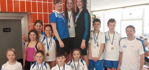 Gruppe junger Schwimmerinnen und Schwimmer mit Medaillen