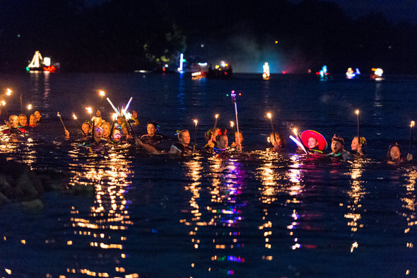 Taucher mit Fackeln schwimmen in der Donau