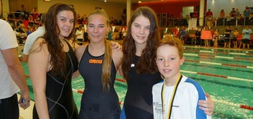 drei Schwimmerinnen und ein Schwimmer lachen in die Kamera