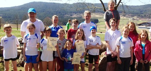 Gruppe junger Schwimmerinnen und Schwimmer mir Urkunden und Trainern